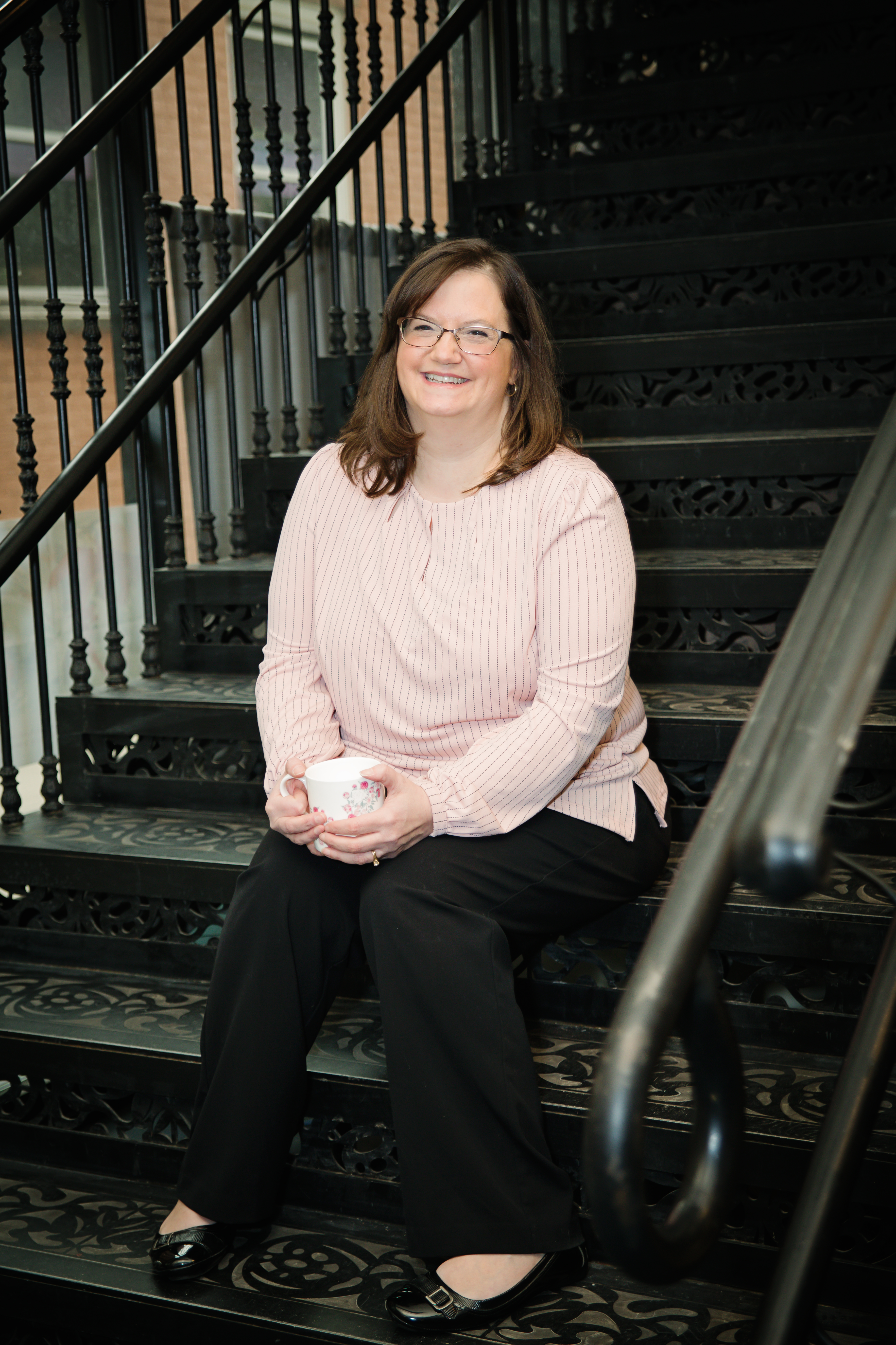 woman sitting on stairs drinking coffee